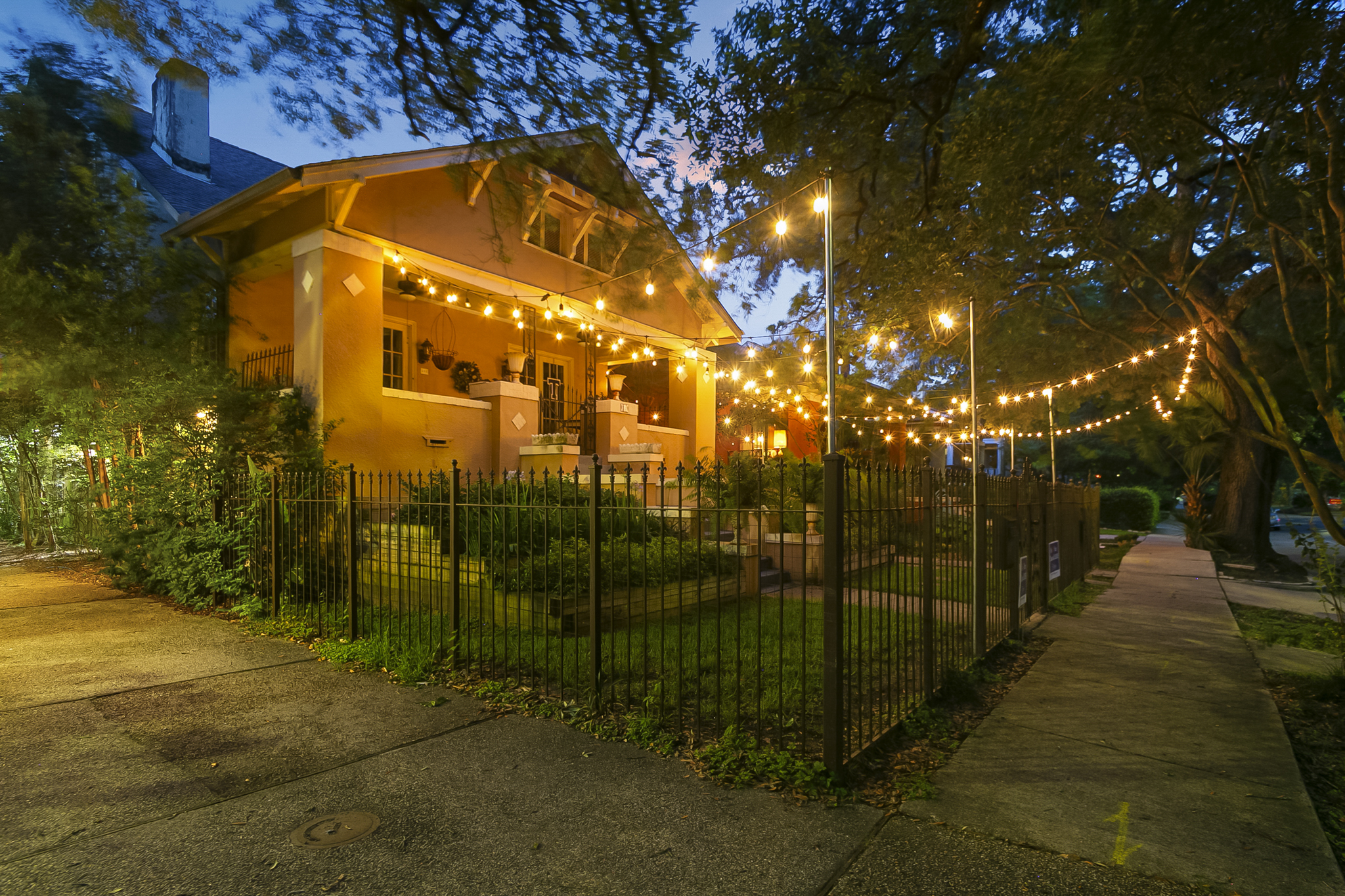 Craftsman home in Mid-City New Orleans lit with string lights at dusk